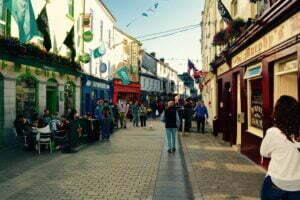 People walking in Galway's Shop street in a sunny afternoon